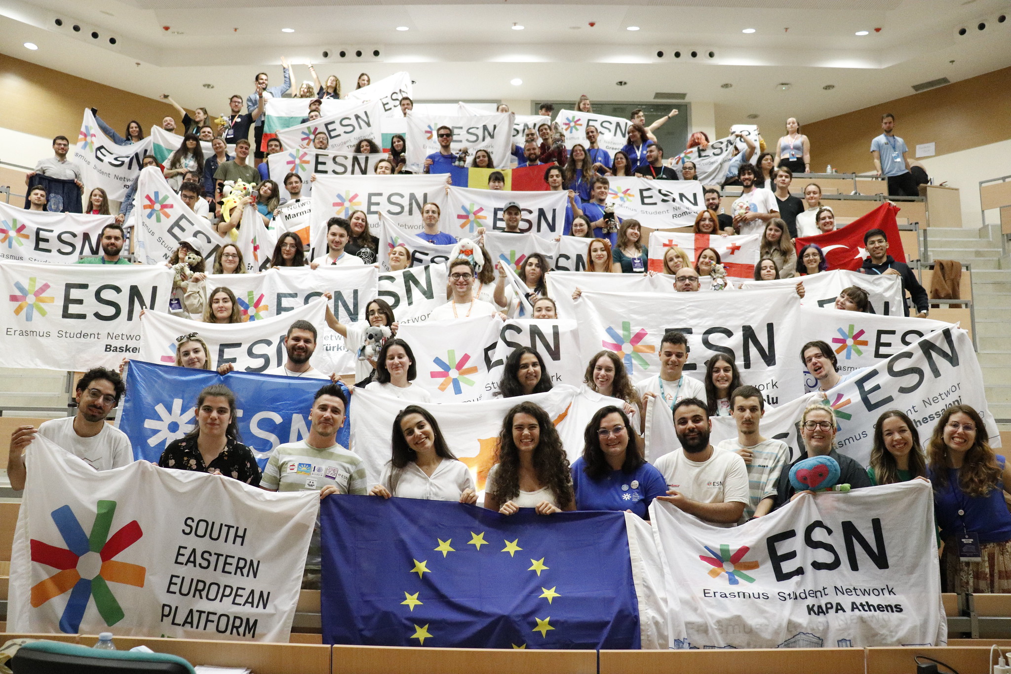 A big group of people holding ESN flags and posing for a picture.