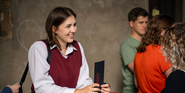 A person smiling and talking to someone.