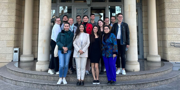 A group of people posing for a picture in front of a building.