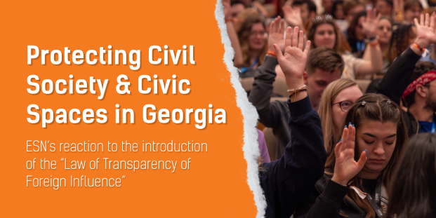Orange piece of paper on a photo of people with one hand raised. "Protecting Civil Society and Civic Spaces in Georgia. ESN’s reaction to the introduction of the “Law of Transparency of Foreign Influence".