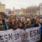 A big group of people standing together with posters and flags.