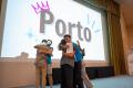 A picture of people hugging on a stage and a screen showing the word "Porto".