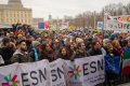 A big group of people standing together with posters and flags.