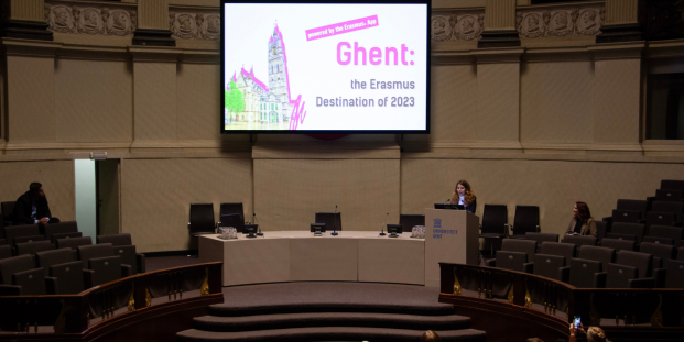 A person having a presentation about Erasmus Destination of the Year 2023 (Ghent, Belgium) in a round room.