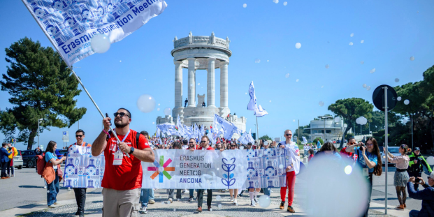 A group of people with colourful flags in front of Pasetto in Ancona, Italy.